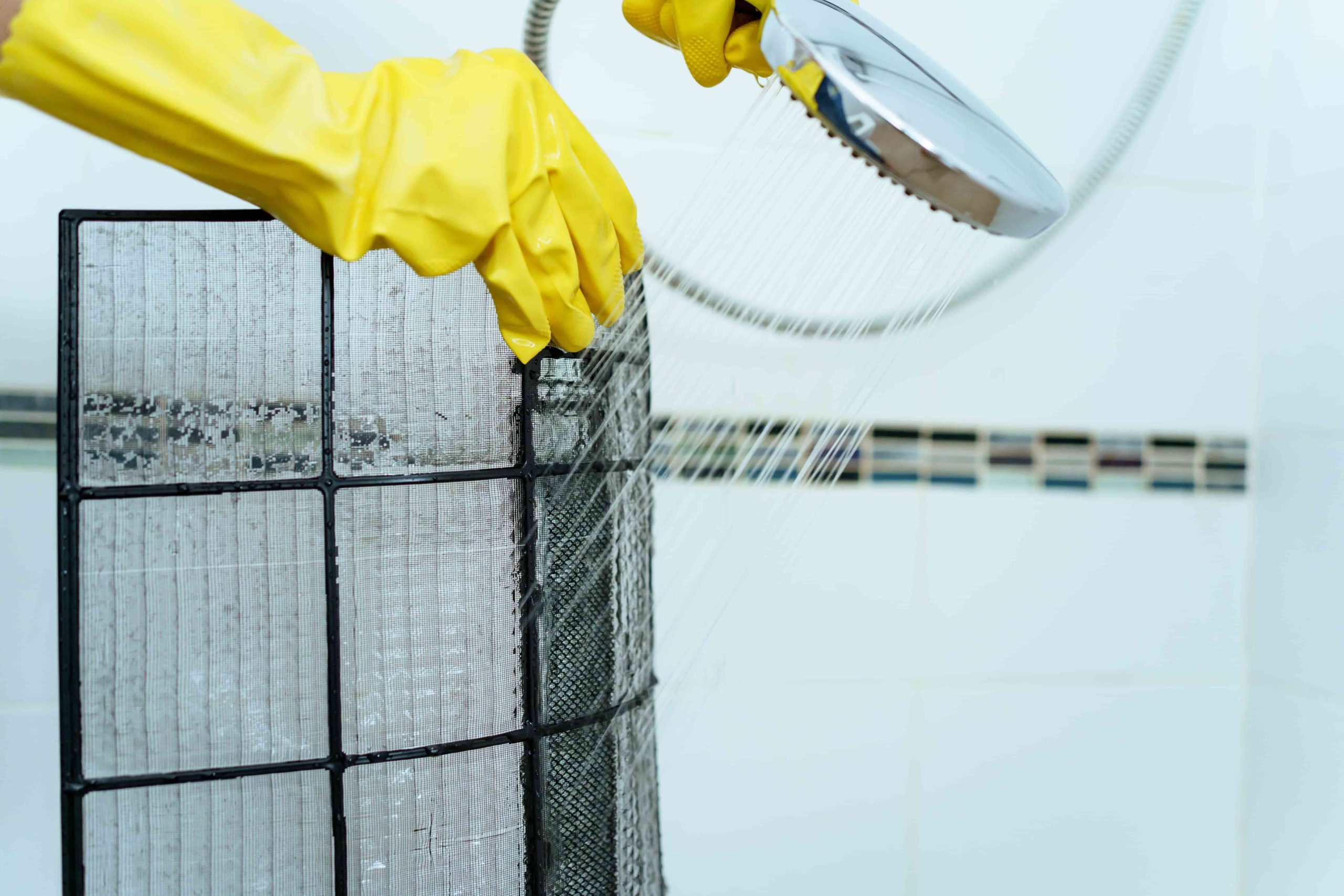 woman cleaning air filter of a mini split ac unit