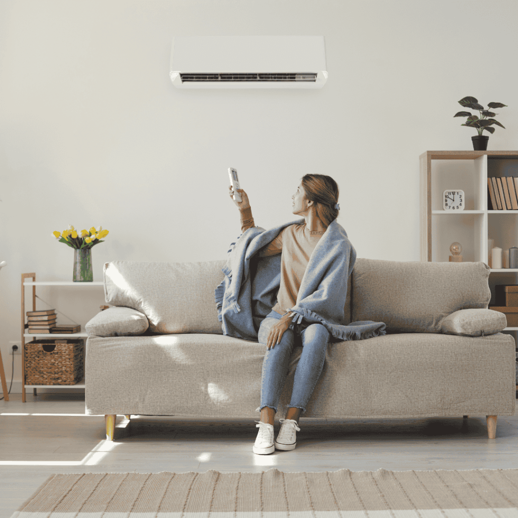 woman resetting her HVAC thermostat to blow hot air 